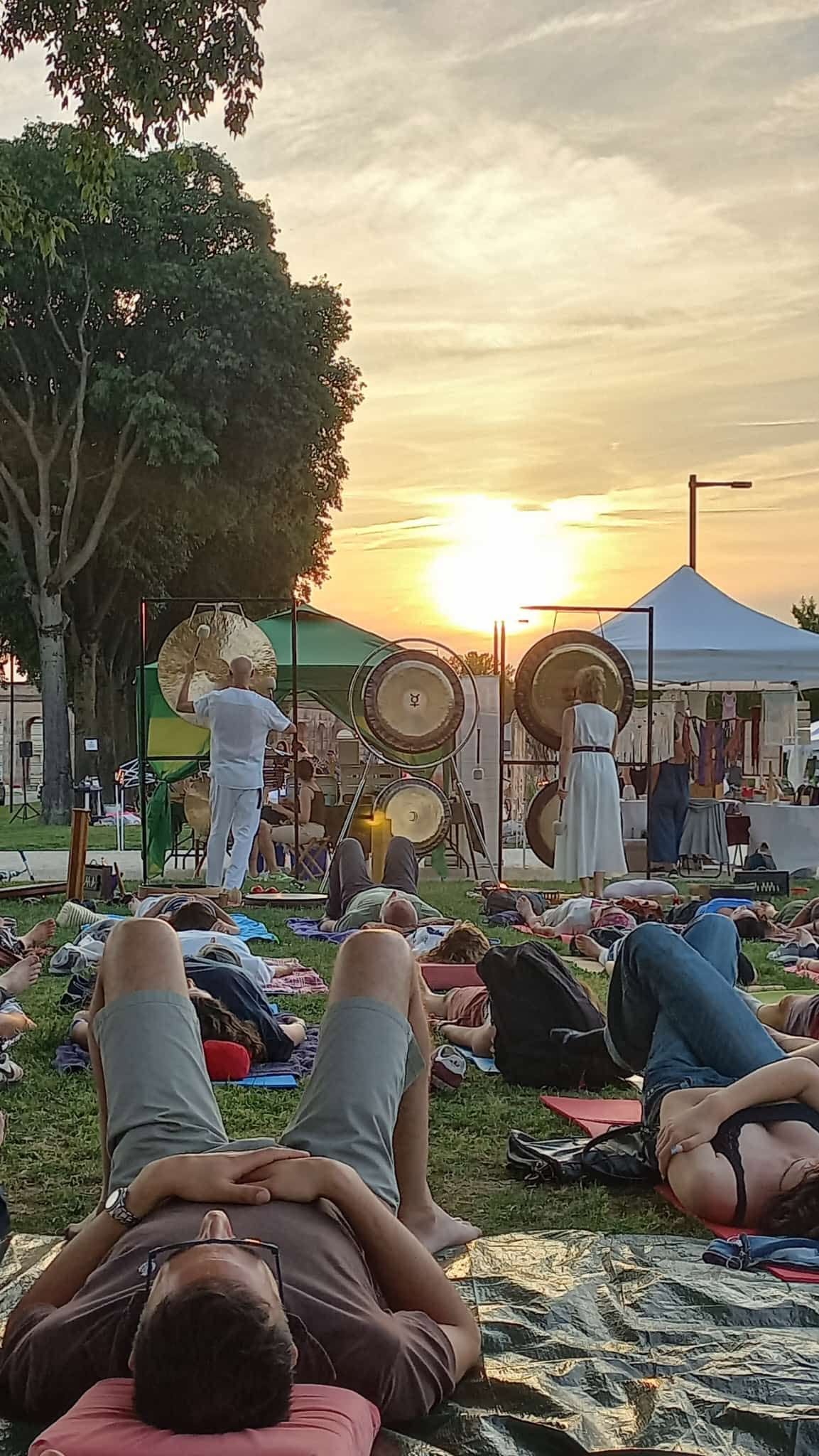 Gong illuminati dal sole al tramonto durante un bagno di suoni all'aperto